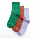 Three pairs of socks in green, terra-cotta and lilac.