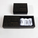 Three white socks with black text on top of the heel in a Layers of Urban box