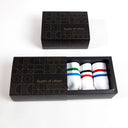 in Layers of Urban box, three pairs of white socks with colorful stripes red-blue, red-black and green-blue.